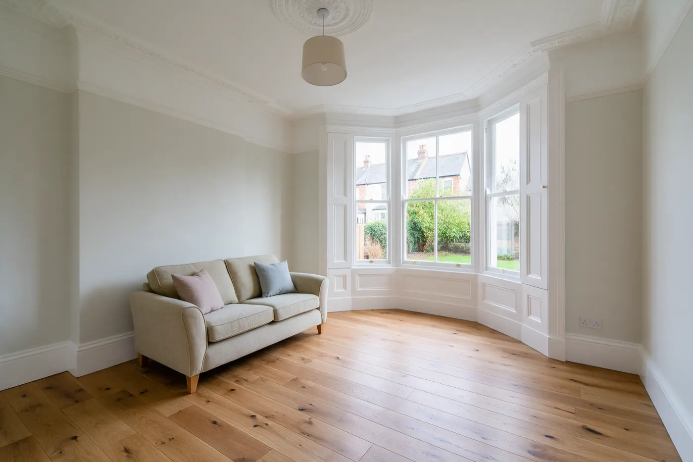 A freshly decorated living room with an oak floor