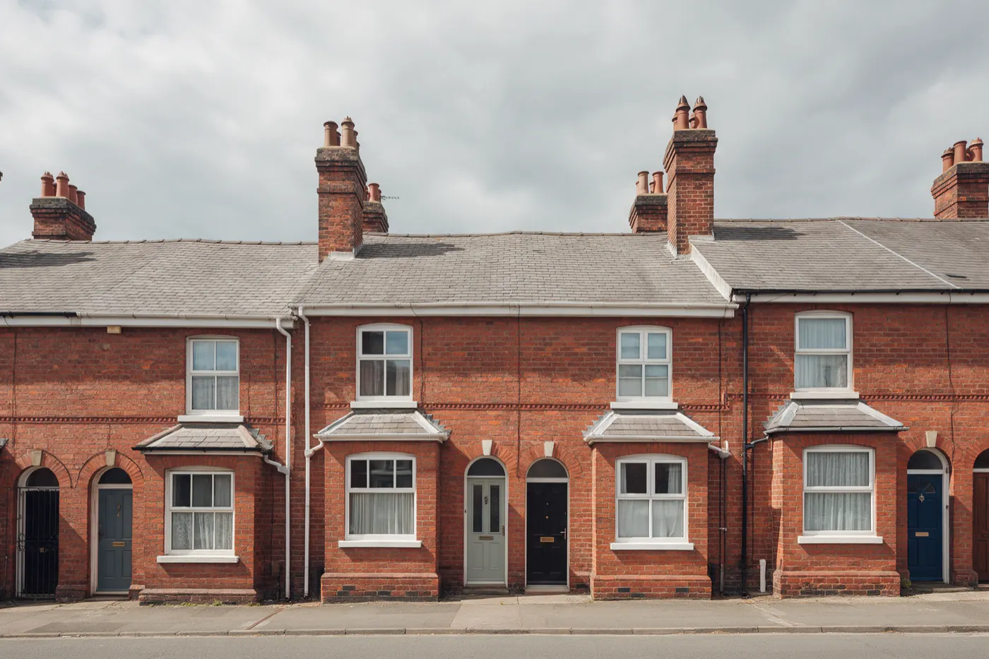 A row of terraced houses with slate roofs and brick chimneys
