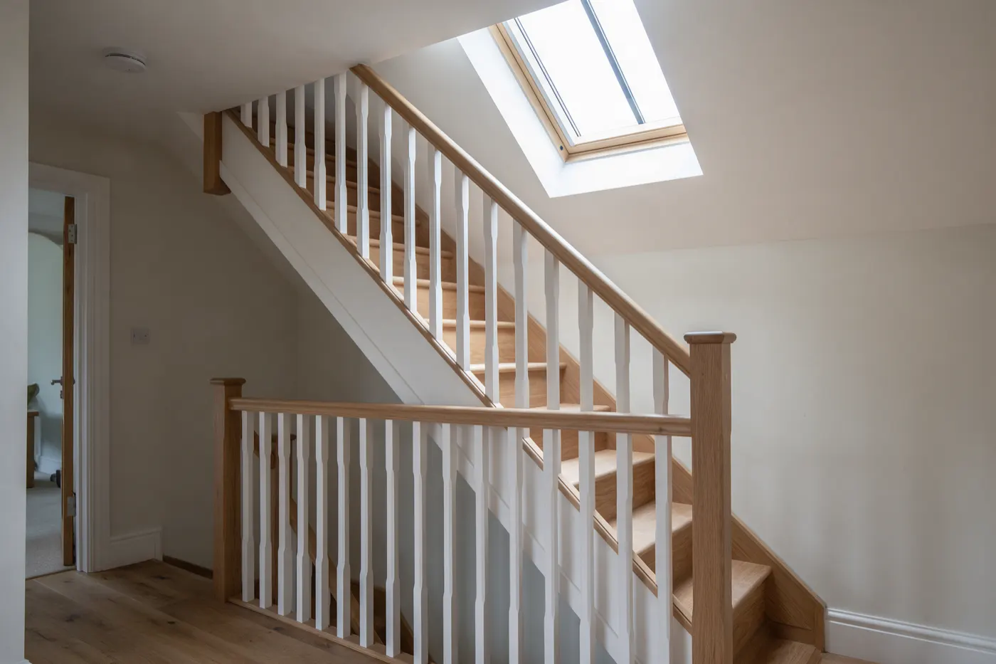 A new staircase leading up to a loft conversion under a sloping ceiling