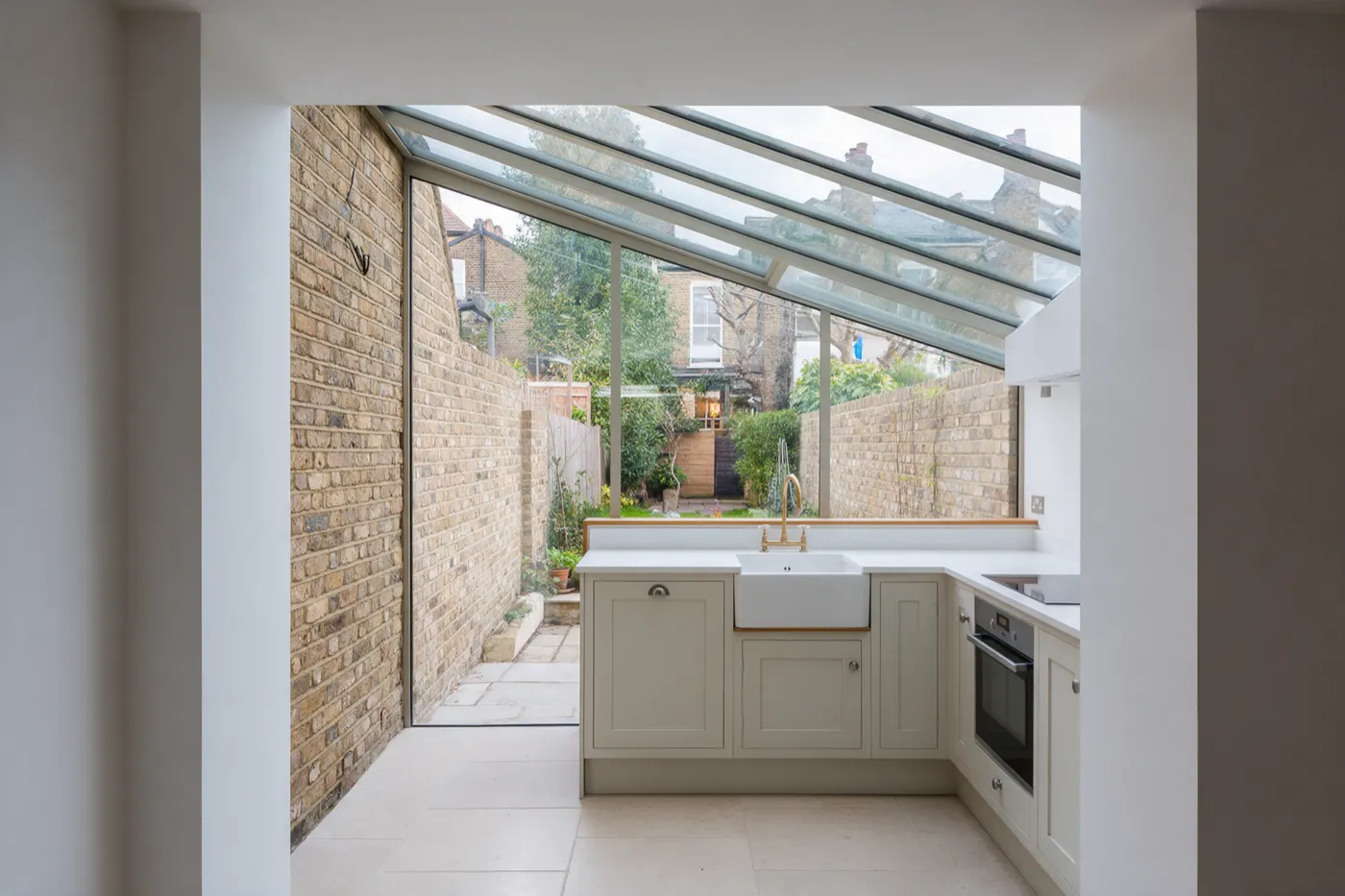 A side return extension on a Victorian terrace, with a glazed roof running along the boundary wall