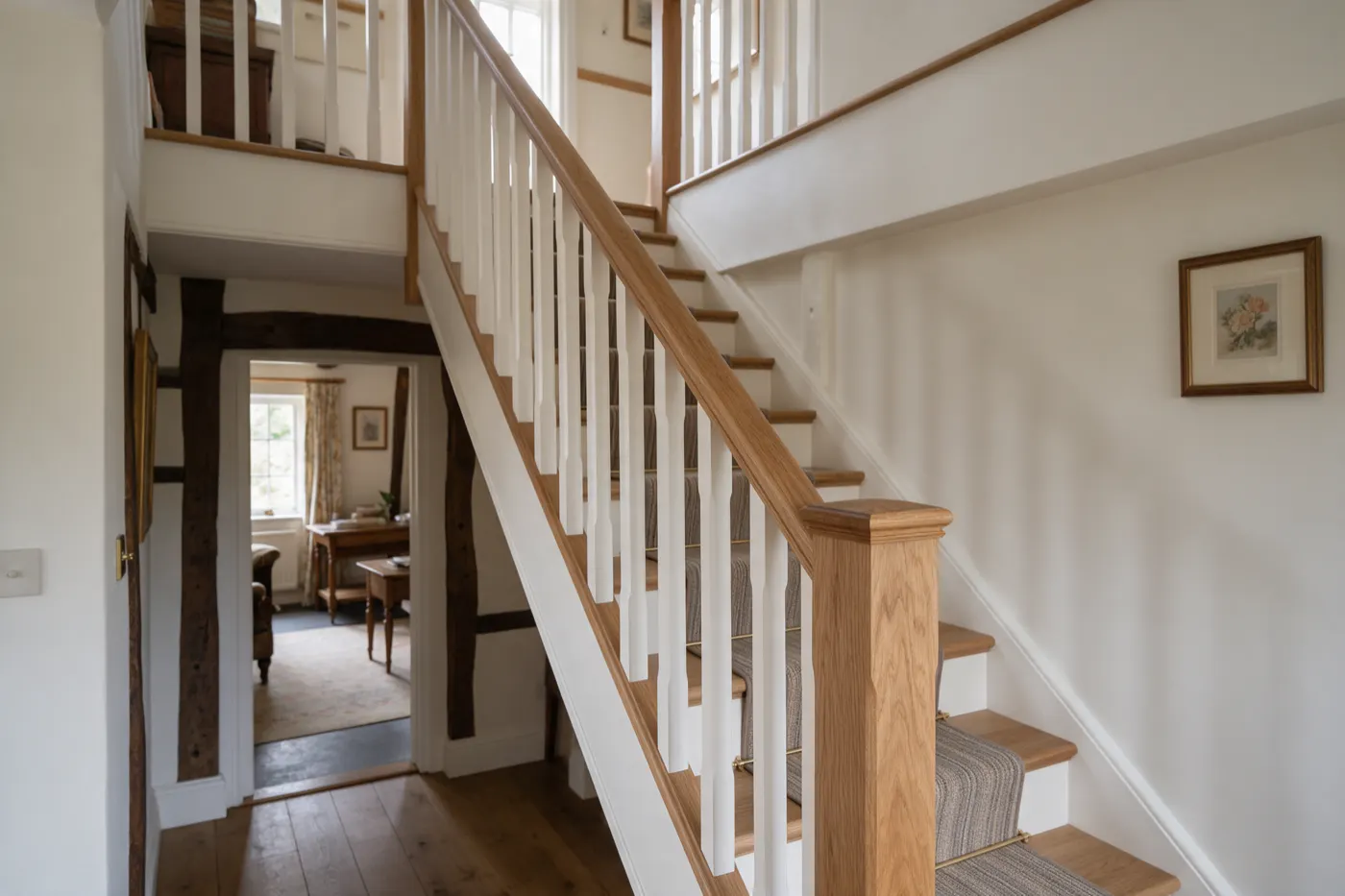 A staircase with an oak handrail and white spindles